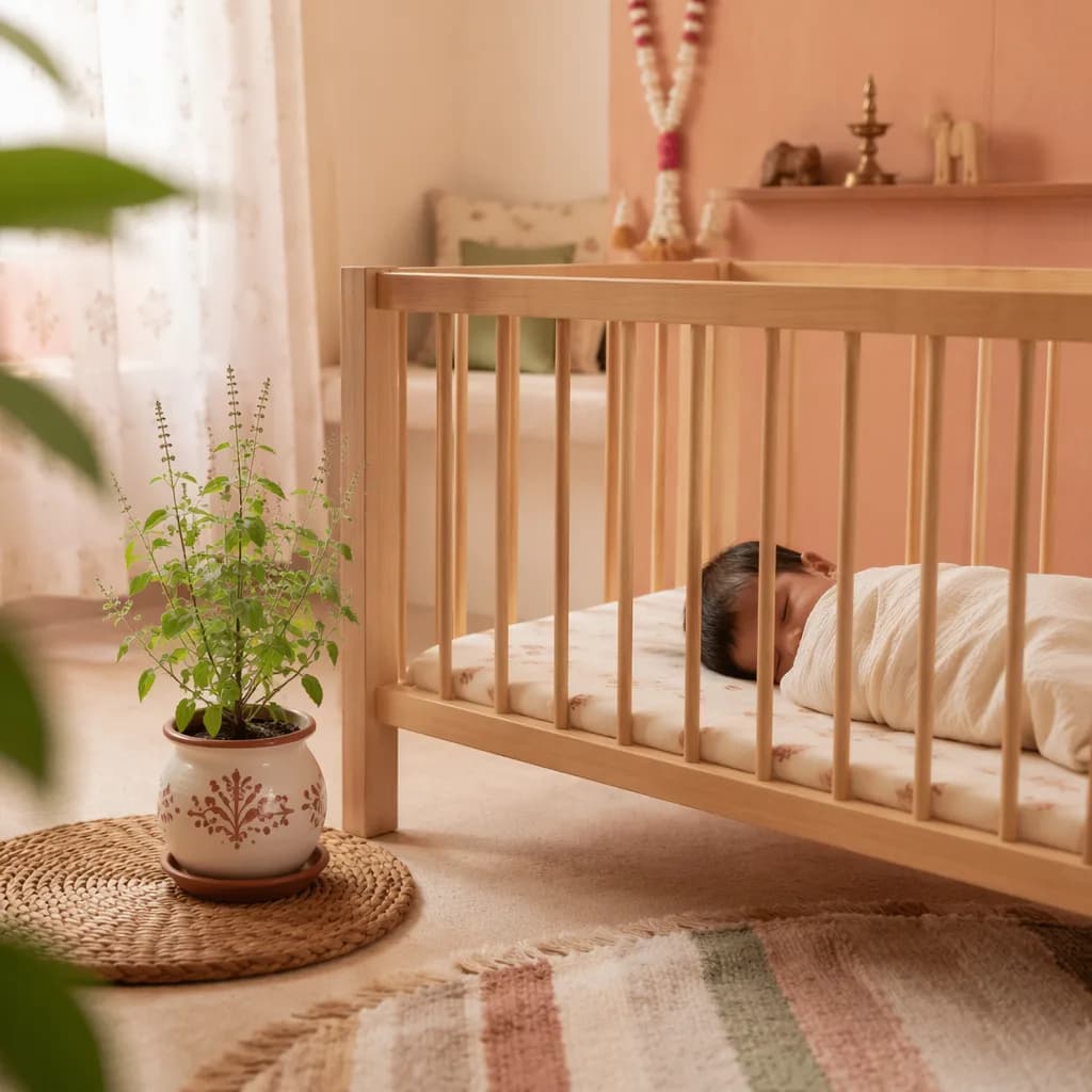 Peaceful Tamil-inspired nursery with a swaddled baby and thulasi plant in soft natural light.